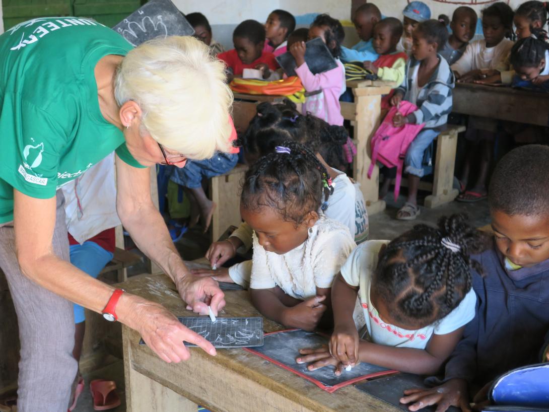 A woman volunteers abroad during her retirement and works with children in Africa. An older volunteer abroad works with children at an Early Childhood Development Centre in Madagascar.
